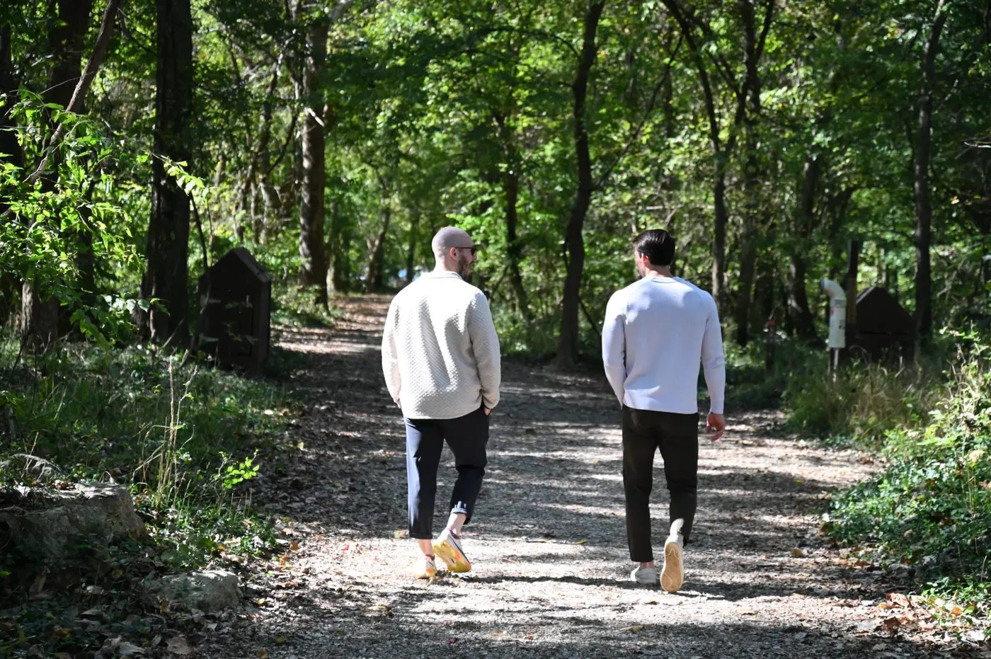 Therapist and client walking a wooded trail away from the camera